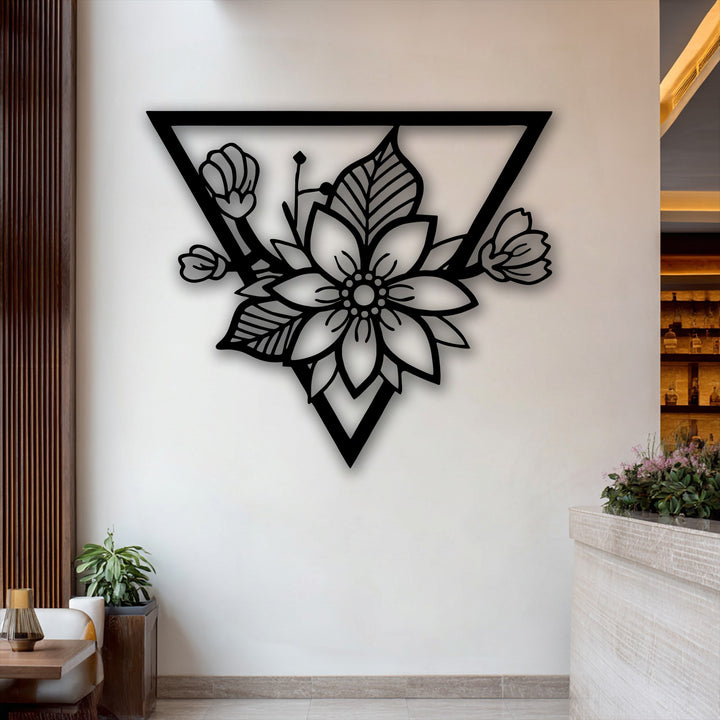 Negative space beautifully outlines the intricate floral patterns within the modern triangle frame of this decorative metal art.