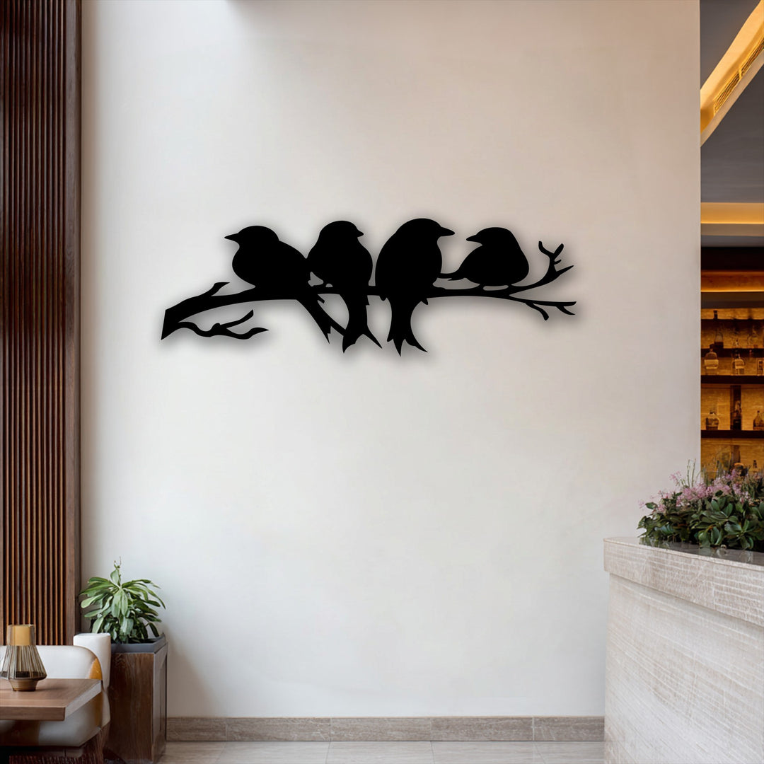 A prominent silhouette of four quiet birds perched together on a sturdy branch, creating unique metal wall art.