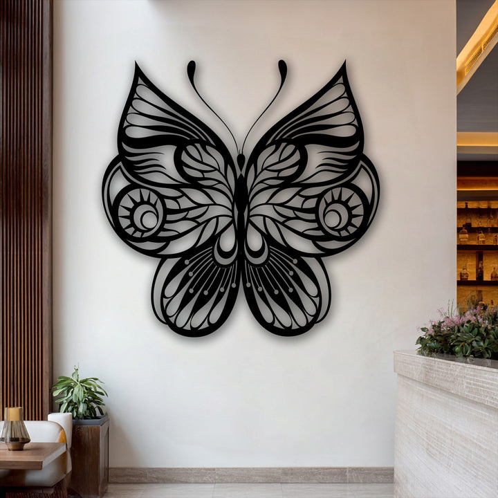 The ornate butterfly metal wall decor features gracefully swirling patterns on its wings, evoking an elegant sense of flowing movement.