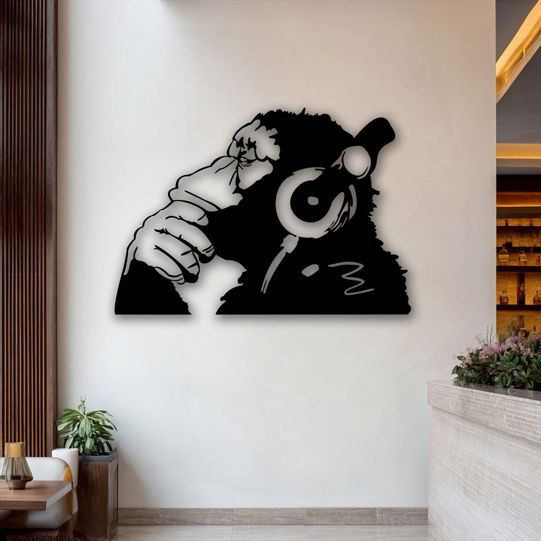 The crisp white wall prominently features a black monkey wearing headphones metal decoration wall art, surrounded by warm wooden accents and subtle greenery.