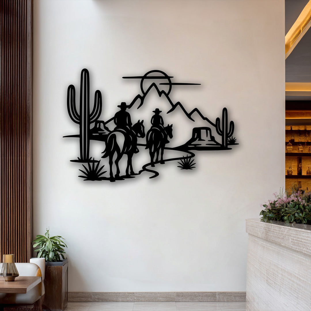 The smooth, matte finish of the black metal artwork depicts a rustic desert scene with cowboy silhouettes, horses, mountains, and cacti.