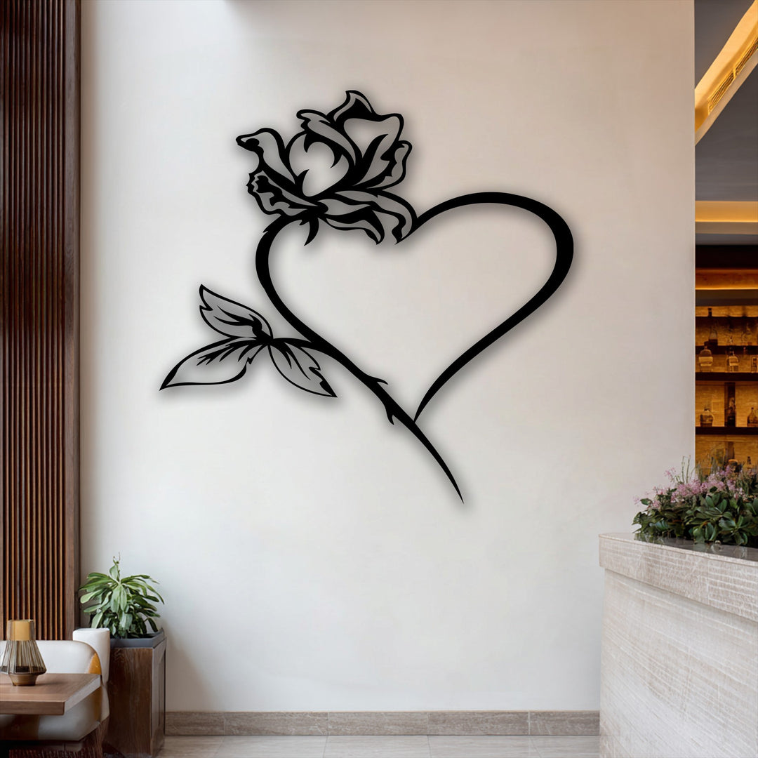 A striking black metal art for wall featuring a rose elegantly growing from a heart, with detailed leaves gracing the lower left.