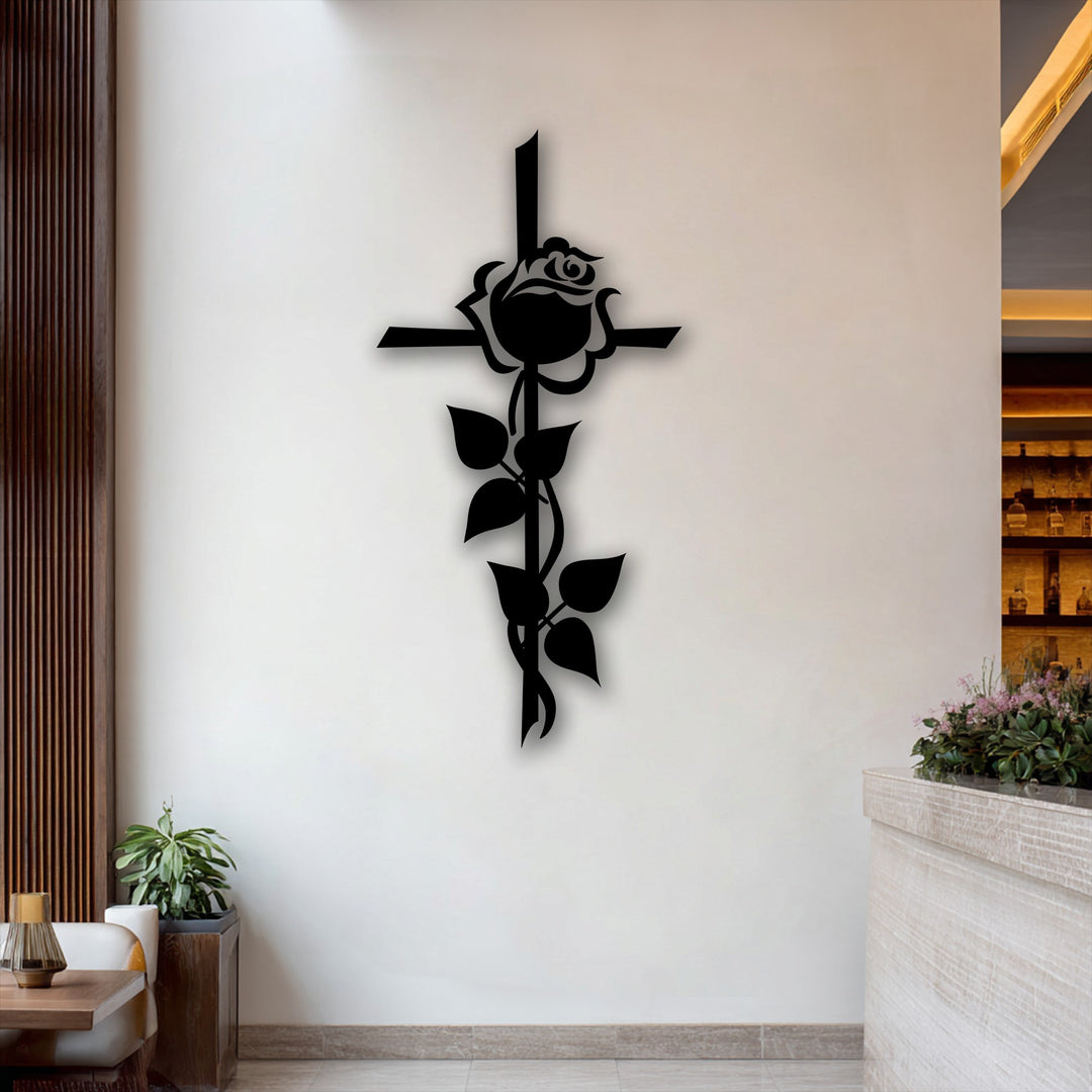 The matte black finish of this unique metal wall art showcases a striking rose cross silhouette, casting a subtle shadow on the white wall.