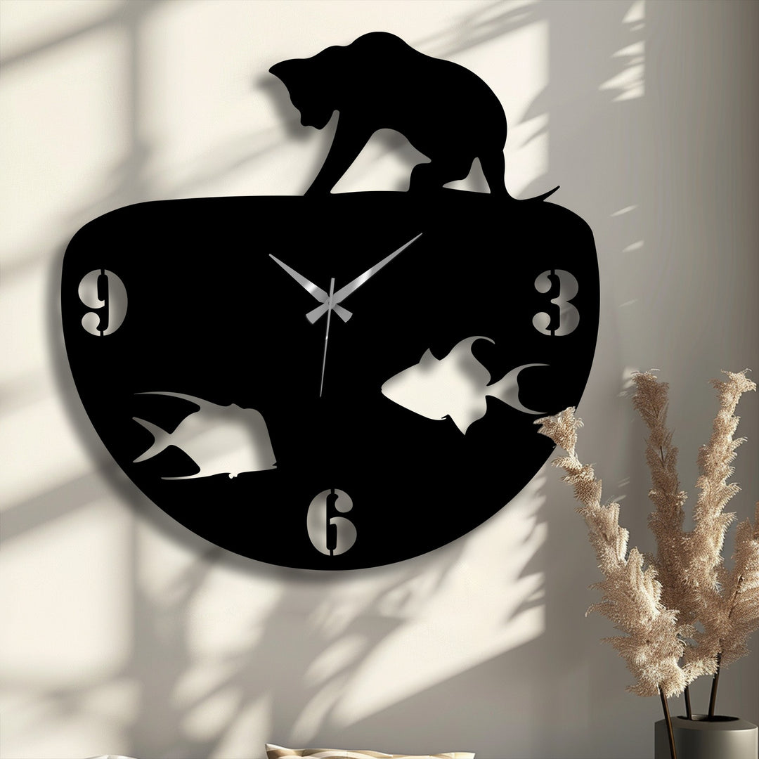 Negative space highlights the sleek, modern black cat and fish bowl unique metal wall art clock on a textured wall.