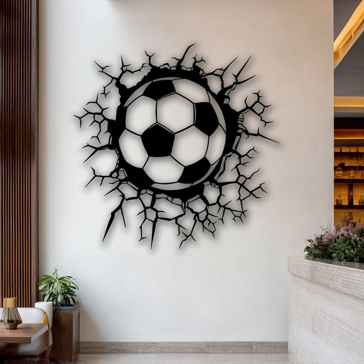 The sleek, matte finish of the breaking wall soccer ball decorative metal art creates a dynamic visual effect on the wall.