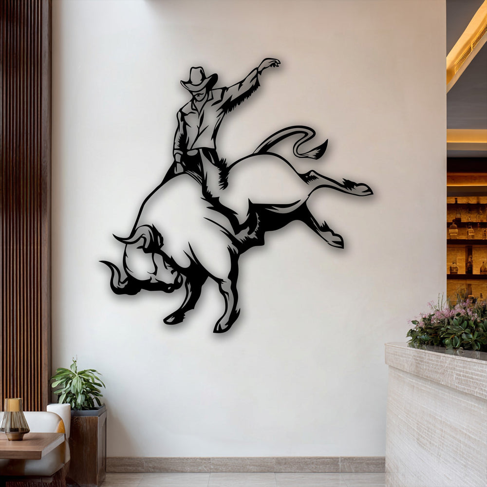 The warm color temperature enhances the dynamic black cowboy bull riding metal wall decor against a bright wall, complemented by inviting wooden accents.