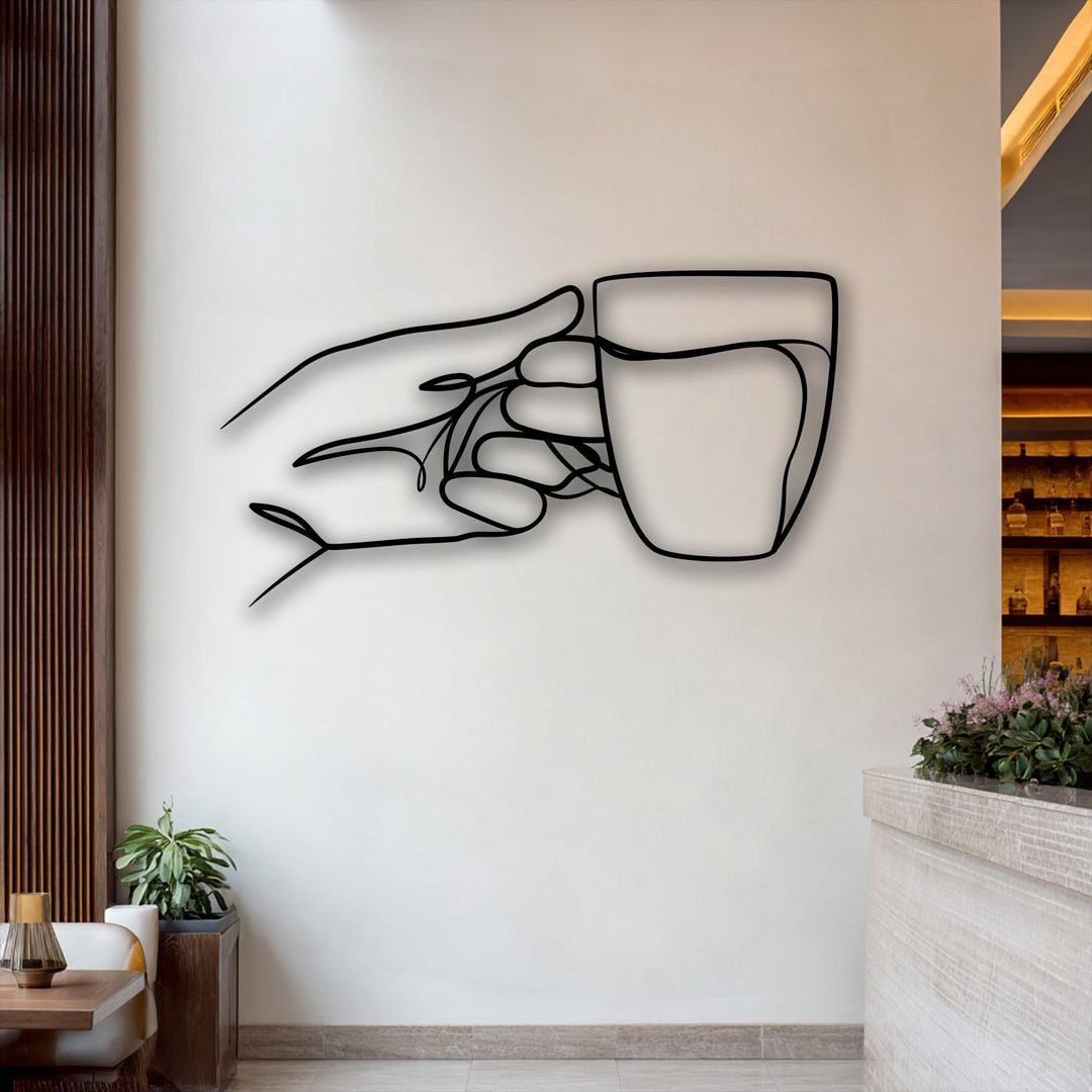 A prominent minimalist line art metal artwork depicting a hand delicately grasping a cup on a light wall.