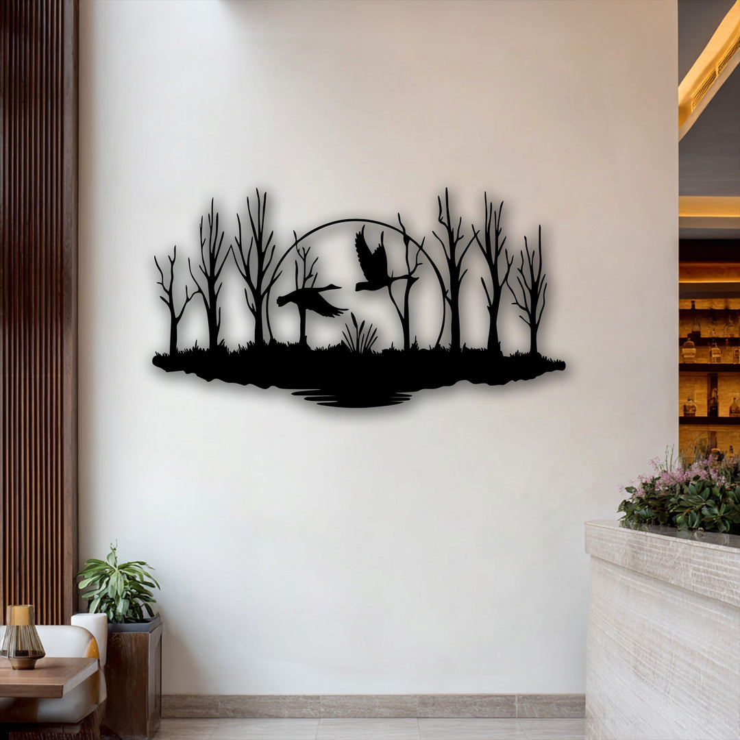 The stark color contrast between the deep black decorative metal art of flying birds in a forest silhouette and the bright wall creates a dramatic visual.