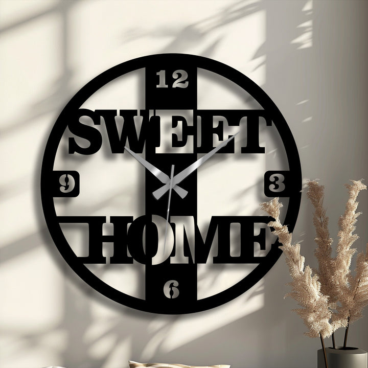 Spinning shadows accentuate the decorative metal art design of this 'Sweet Home' wall clock, giving a sense of time flowing in a modern aesthetic.