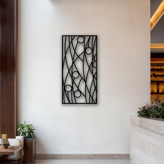 The focal point is a striking black abstract linear geometry metal artwork featuring circles, mounted on a pristine white wall.
