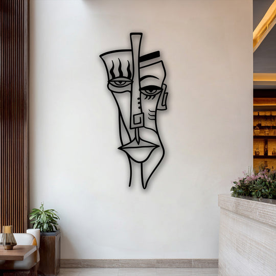 The subtle shift from the bright white wall to deep wood and soft counter textures beautifully frames this abstract tribal face metal wall decor.