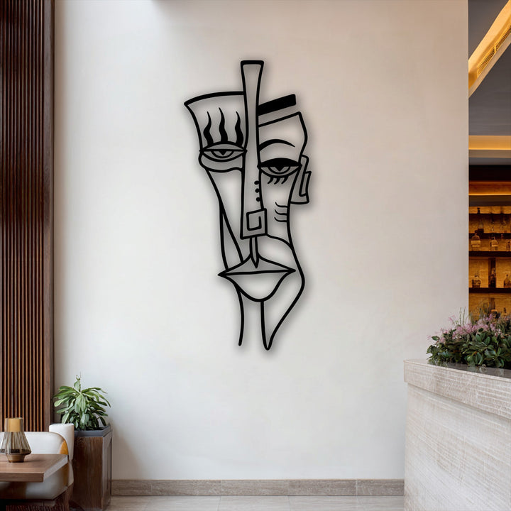The subtle shift from the bright white wall to deep wood and soft counter textures beautifully frames this abstract tribal face metal wall decor.