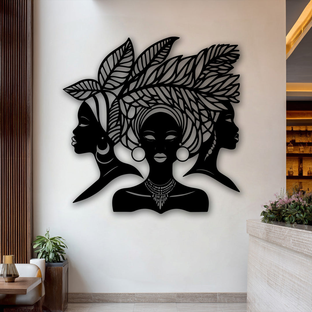The organic forms of this unique metal wall art capture the elegant cultural silhouette of three African queens with intricate leafy headdresses.
