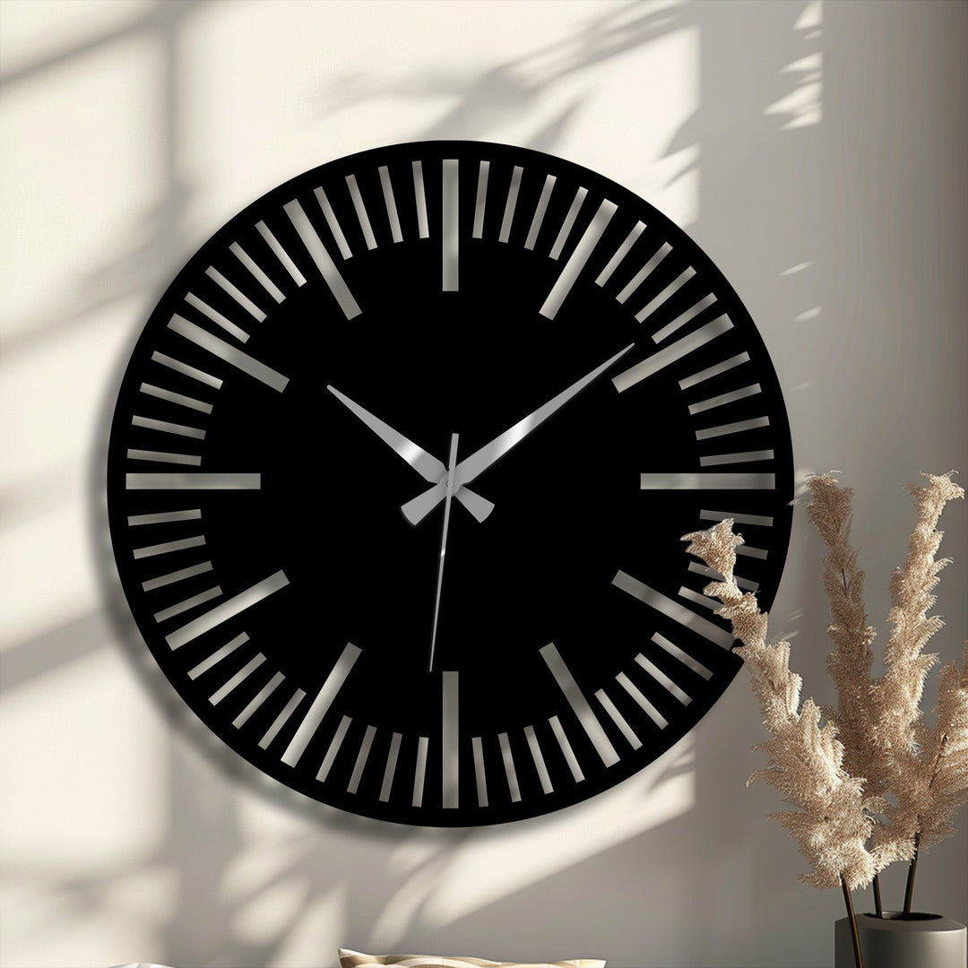 The sleek, black metal wall clock with its minimalist dial is the focal point, offering a modern touch with hanging wall art elements.