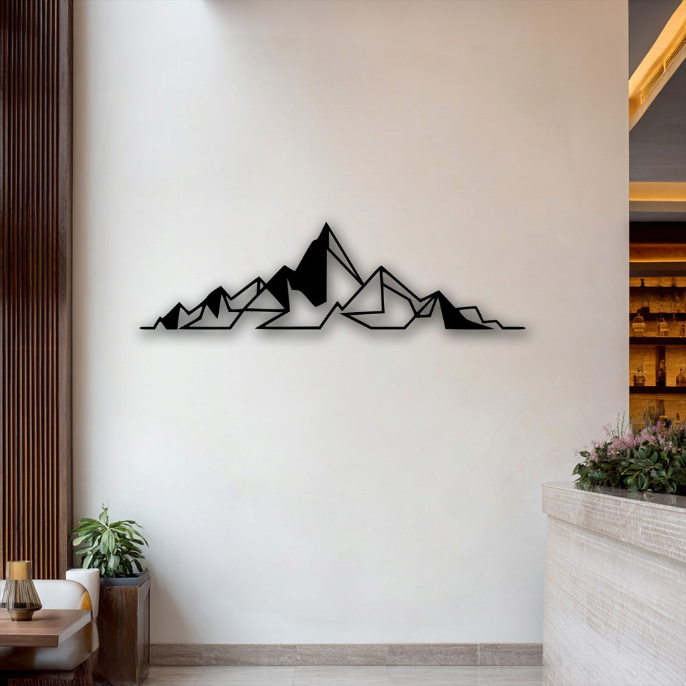 The negative space around the black geometric abstract mountain decorative metal art creates a striking minimal line design on a white wall.