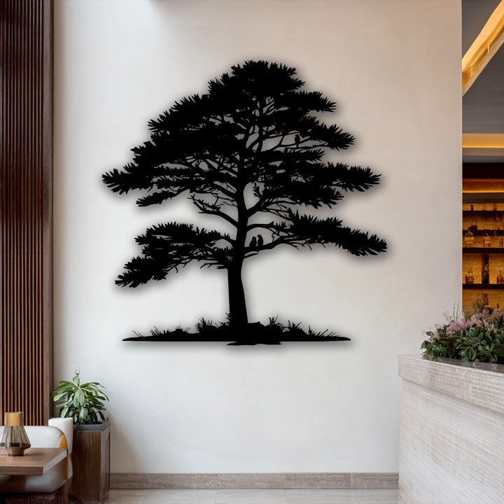 The soft interplay of light and shadow beautifully defines this intricate pine tree silhouette metal artwork against a bright wall.