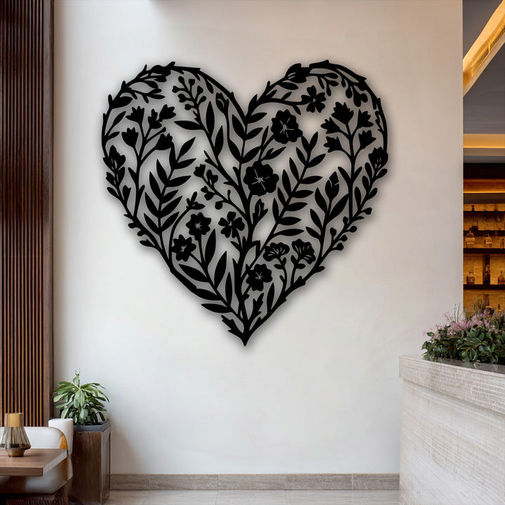 The crisp black edges and intricate borders of the botanical heart floral metal decoration wall art stand out on the white wall.