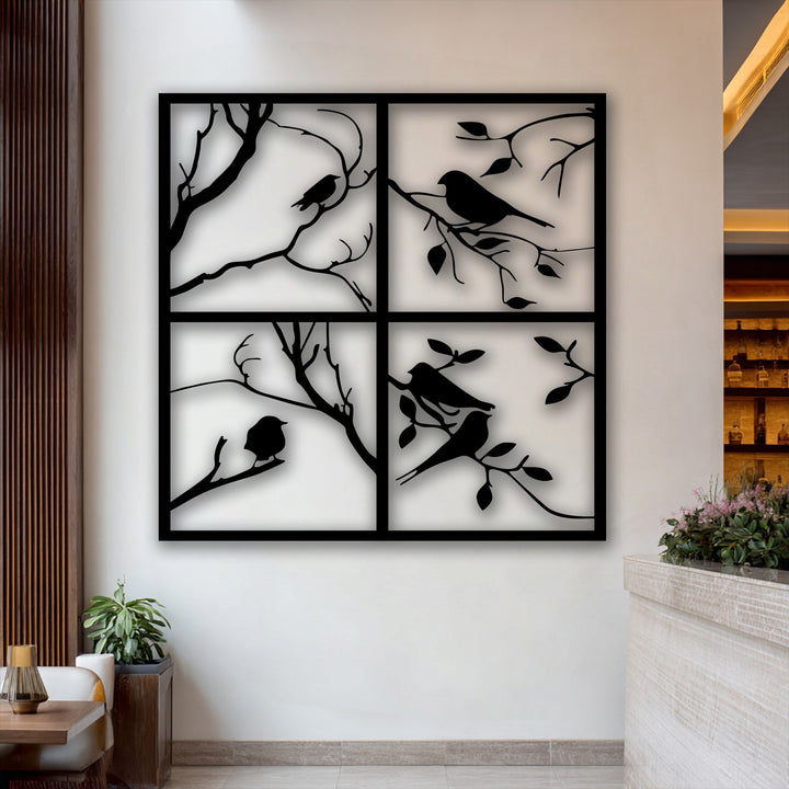 A clean, neutral-toned wall forms the background for the elegant four panel bird silhouette metal artwork, complemented by warm wooden accents.