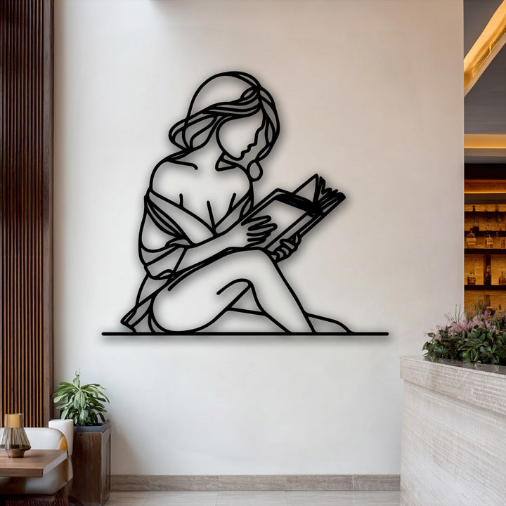 The gentle transition from the soft white wall to the bold black unique metal wall art of a quiet reader silhouette.