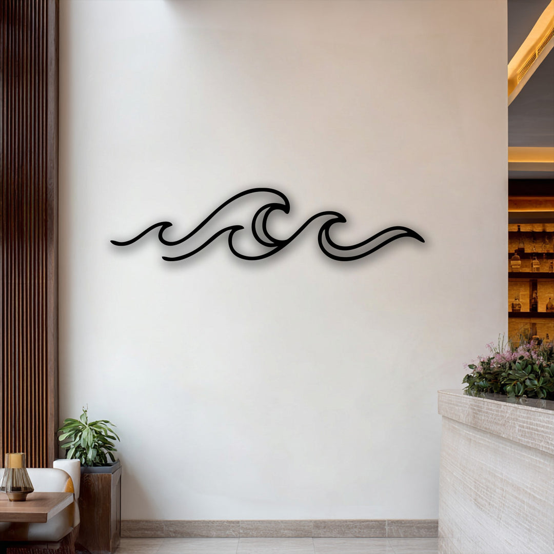 The focal point is the elegant black minimalist ocean wave design, a beautiful piece of decorative metal art, mounted on a bright white wall.