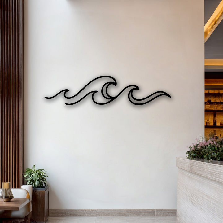 The focal point is the elegant black minimalist ocean wave design, a beautiful piece of decorative metal art, mounted on a bright white wall.