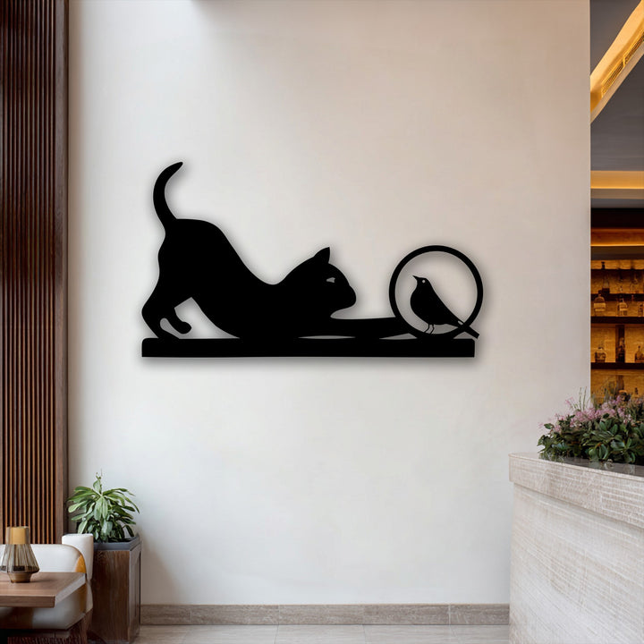 A creamy white wall showcasing a striking black unique metal wall art featuring a playful cat and curious bird silhouette.