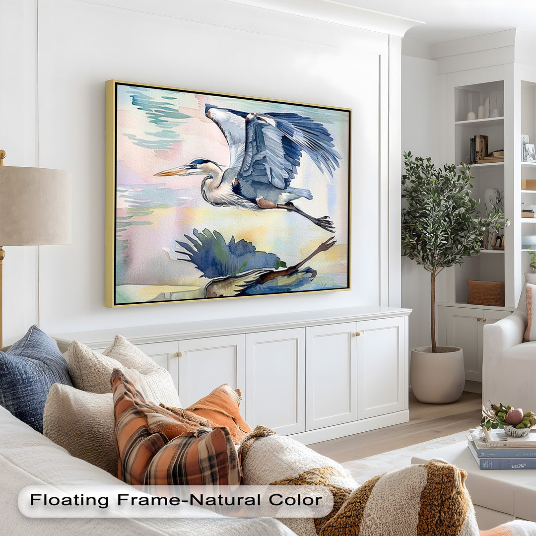 Graceful watercolor painting of a heron in mid-flight above water, with wings fully extended and a soft reflection beneath it.