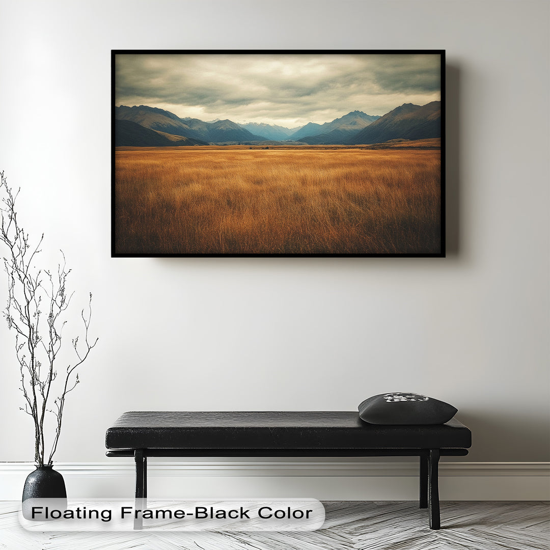 Serene mountain valley scene with golden grasslands and moody skies.
