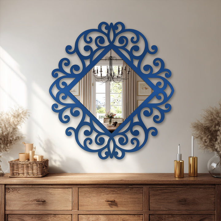 Foreground shows a carved wooden cabinet supporting a blue-framed wall mirror, illustrating classic framed wall mirror styles featuring an ornate baroque metal frame and decorative scrollwork.