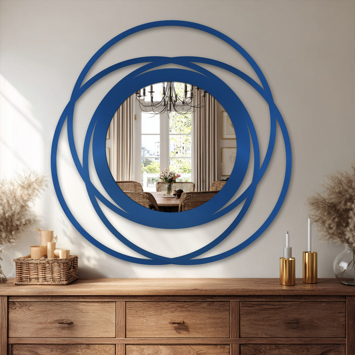 Bold azure rings dramatically contrast against the light neutral wall in this striking circle mirror for wall decor, reflecting a bright dining space.