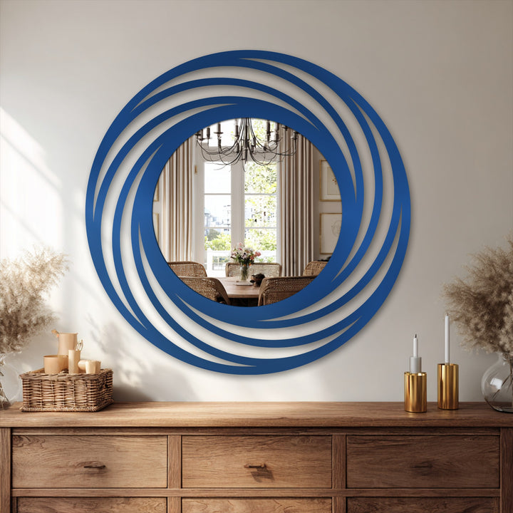 Depth and layers in this decorating with wall mirrors is created by the swirling ring frame of this round mirror, lending a modern focal point.