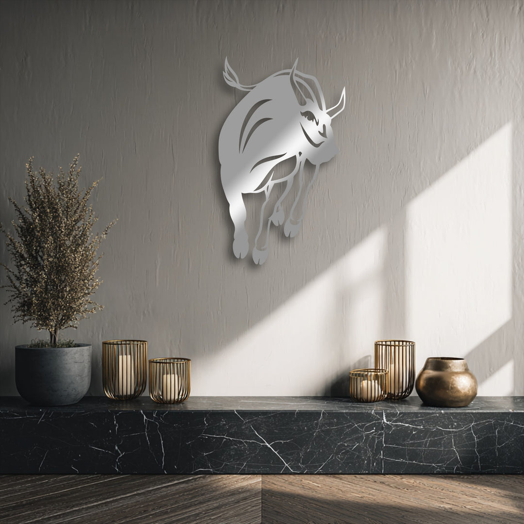 The delicate, feathery dried plant beautifully contrasts with the bold charging bull decorative metal art above a marble surface.