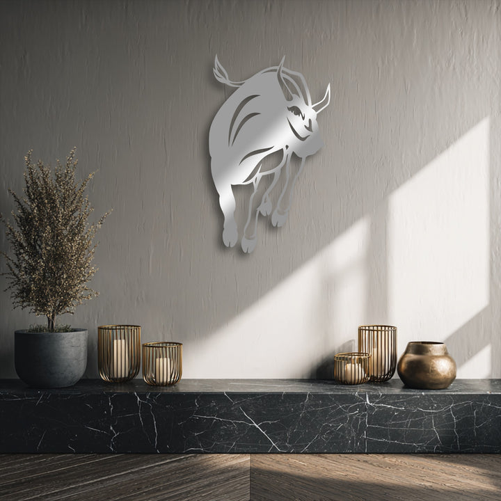 The delicate, feathery dried plant beautifully contrasts with the bold charging bull decorative metal art above a marble surface.