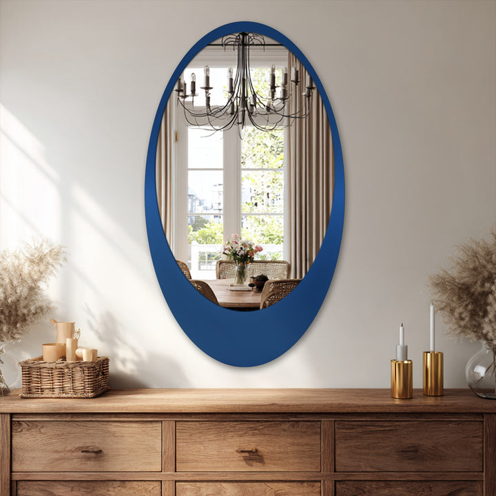 The darkest area highlights the sleek, navy frame of the minimal oval floor stained glass wall mirror, reflecting a bright dining room interior.