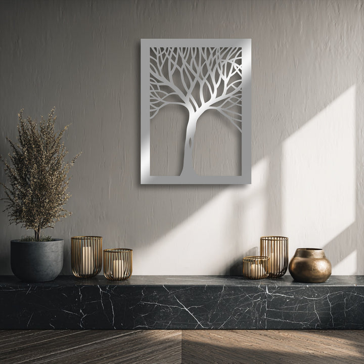 The warm color temperature highlights the intricate abstract tree silhouette metal wall decor, contrasting with cool wall tones and casting inviting shadows.