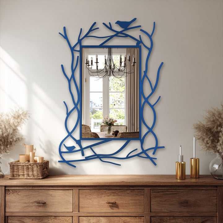 Smooth surface texture highlights the bird detail of a nature-inspired branch frame decorative metal art mirror for wall decor, reflected within the mirror.