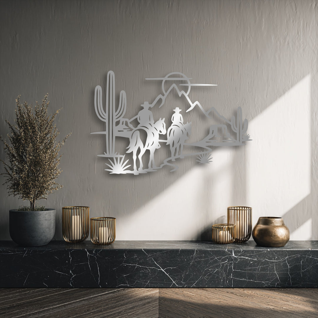 An abstract metal artwork shows a minimalist desert landscape with two cowboy silhouettes, saguaro cactus, and mountains.
