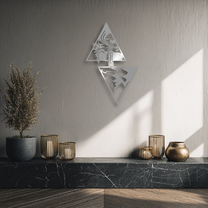 The stark color contrast highlights the silver geometric waterfall metal artwork against the dark marble and bright wall.