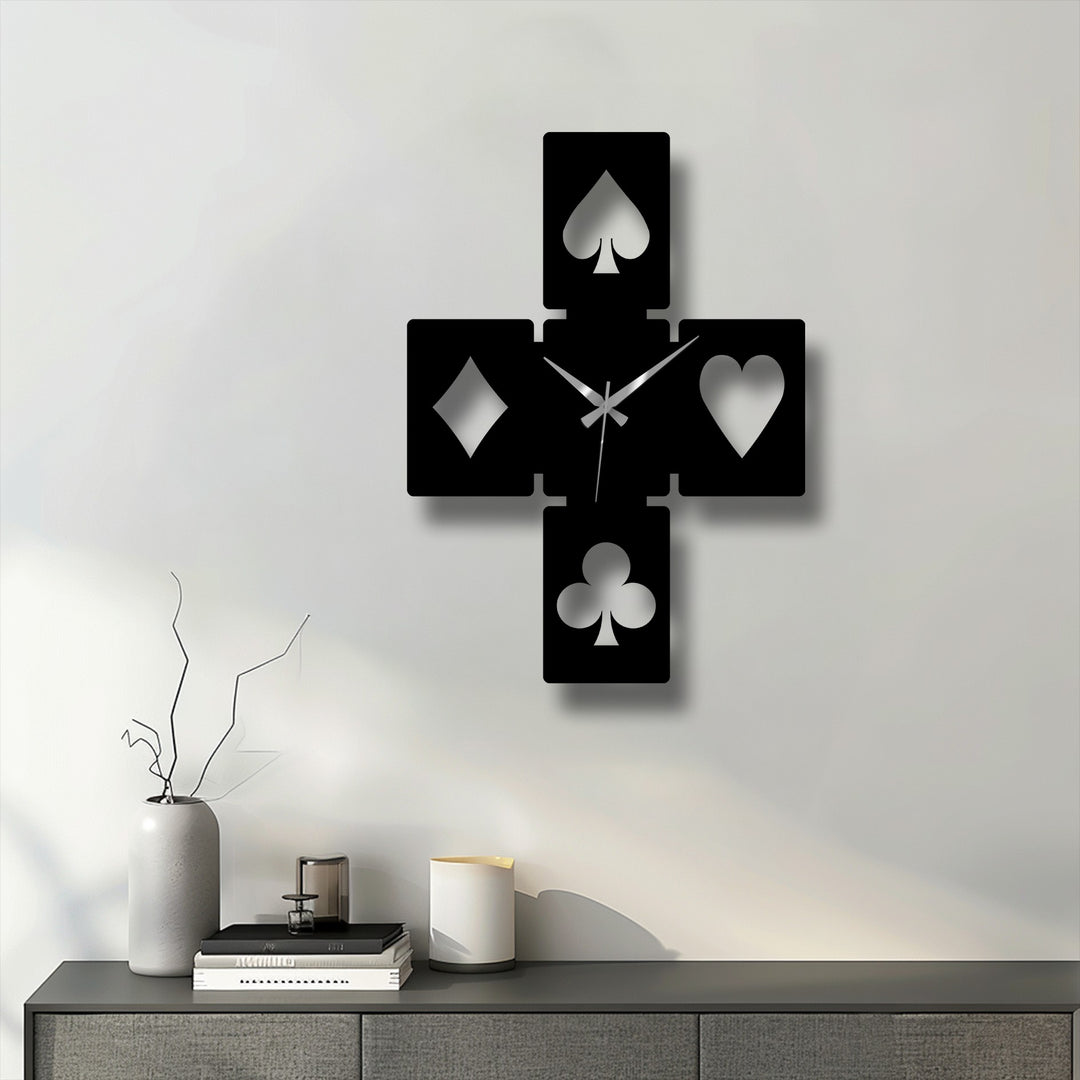 Foreground features a grey console with a tall vase, stacked books, and candle holders beneath the striking decorative metal art.