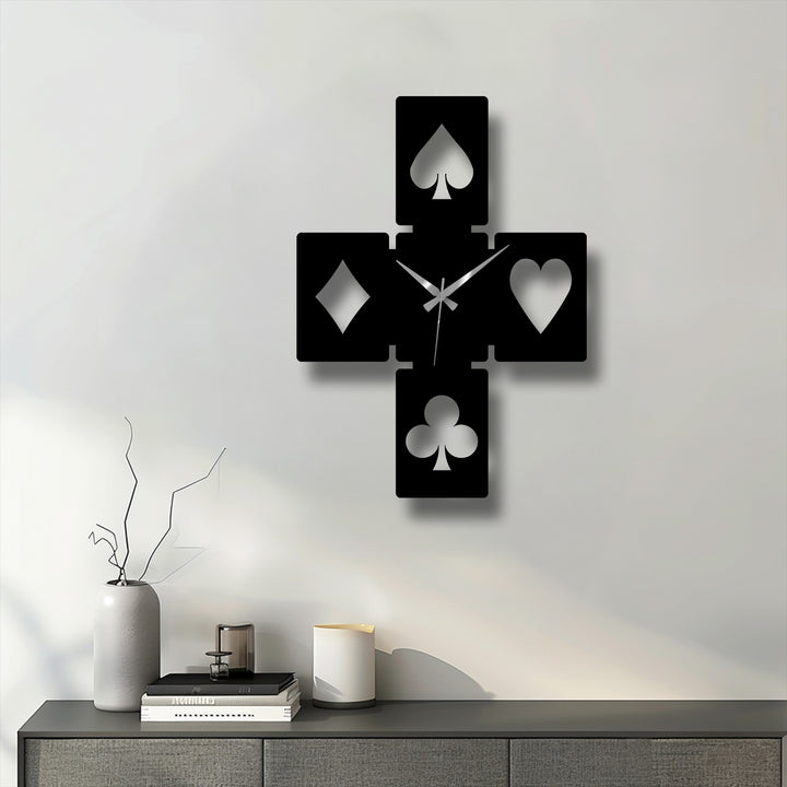 Foreground features a grey console with a tall vase, stacked books, and candle holders beneath the striking decorative metal art.