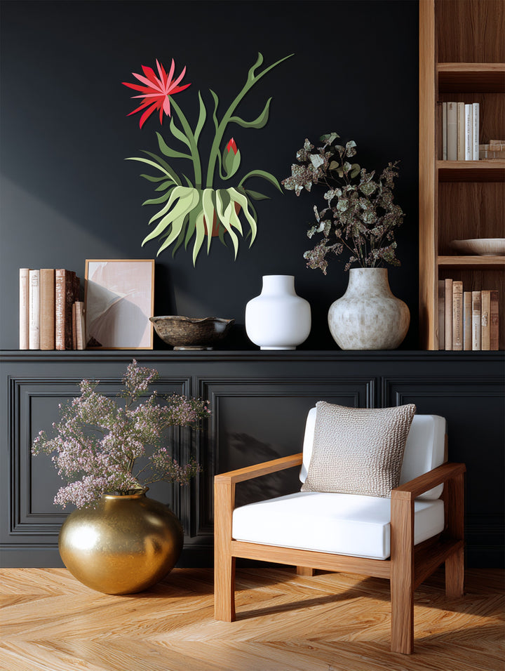 Against a dark paneled wall, the Red Bloom Hanging Plant decorative metal art pops, adding a touch of botanical modernism as a home decoration.