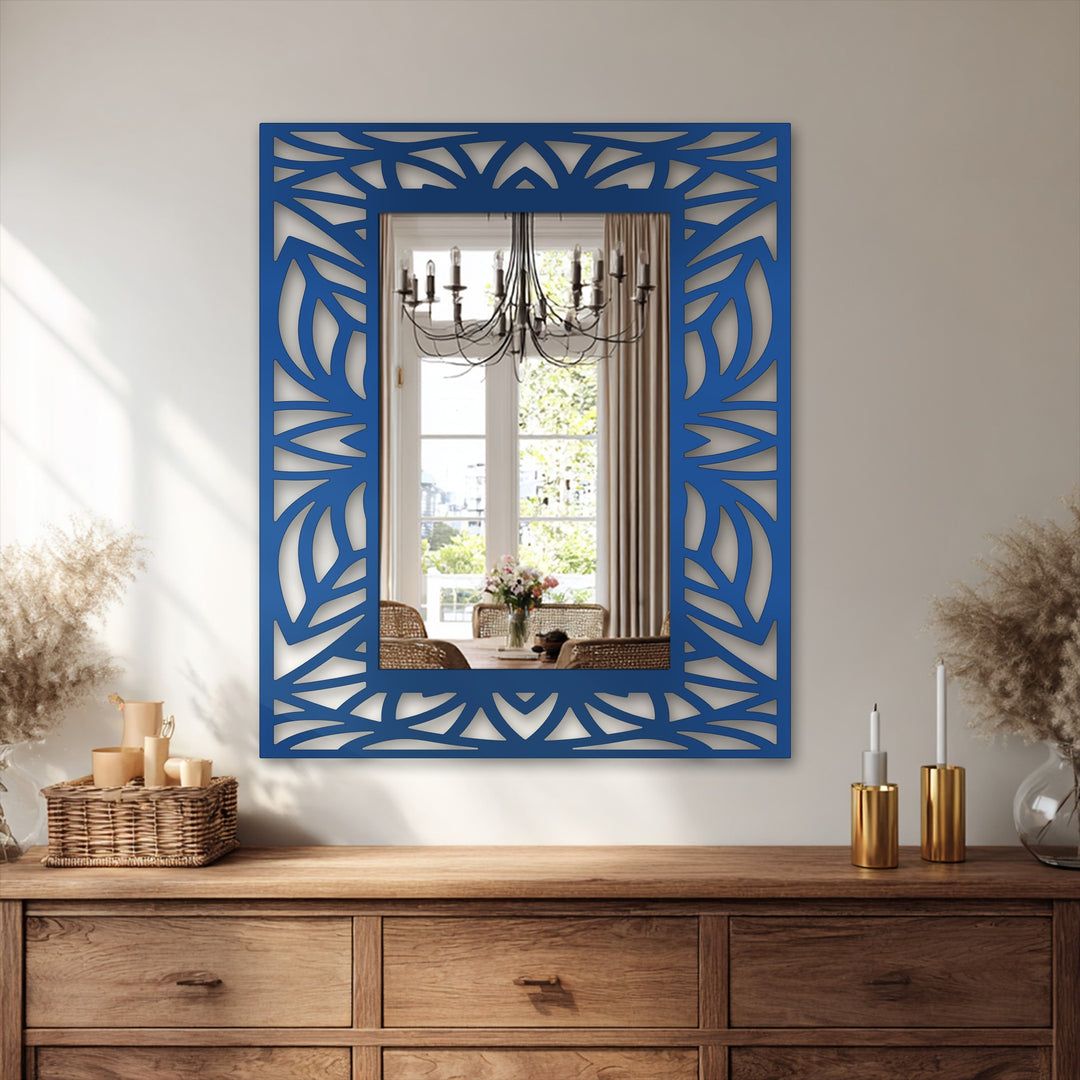 The sleek blue finish highlights the intricate, laser-cut design of this stained glass wall mirror, featuring a modern tropical leaf silhouette frame.