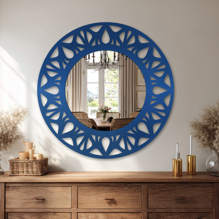 Bright white wall strikingly contrasts with the navy floral cutout frame of this modern mirror, enhancing its sleek statement design.