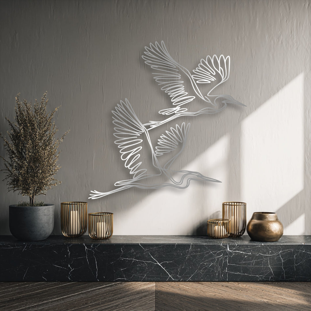 The sleek, sharp edges and clean borders of the graceful flying herons minimalist decorative metal art stand out.