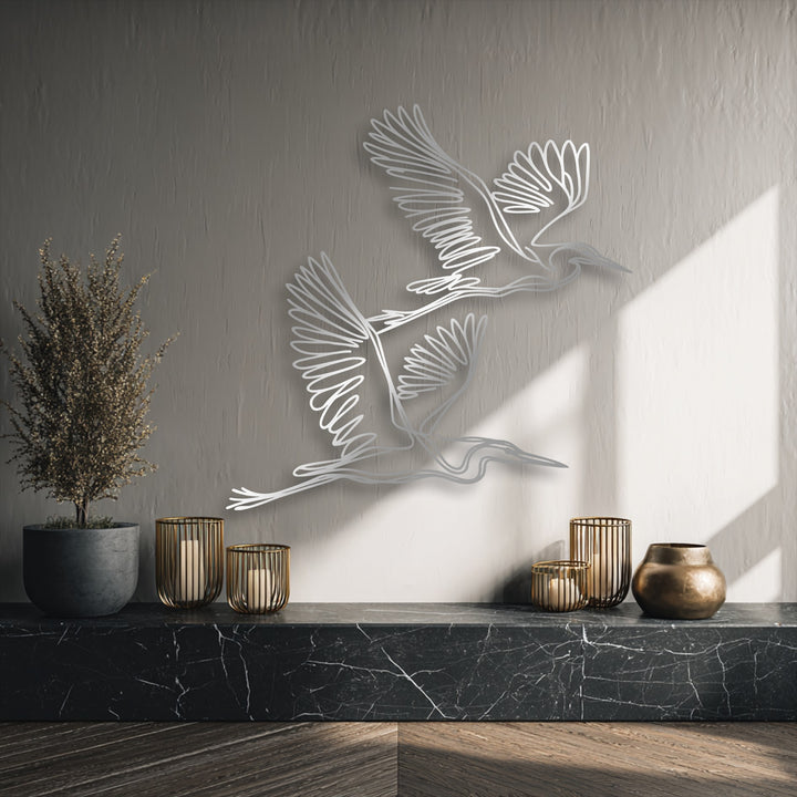 The sleek, sharp edges and clean borders of the graceful flying herons minimalist decorative metal art stand out.