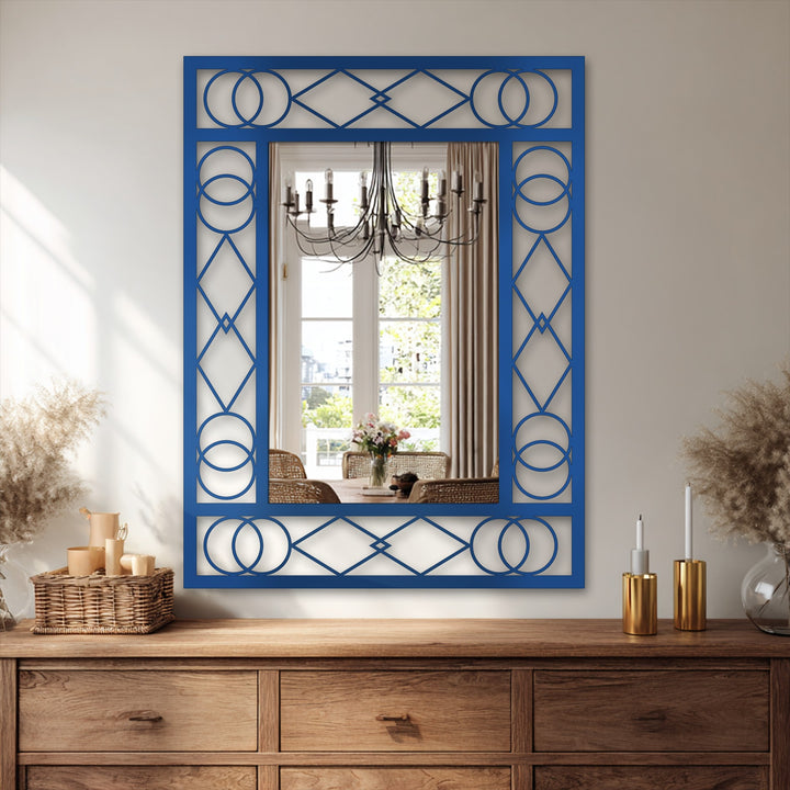 The realistic detail showcases a blue geometric bathroom mirror with a decorative metal frame, reflecting a dining room and chandelier with clarity.