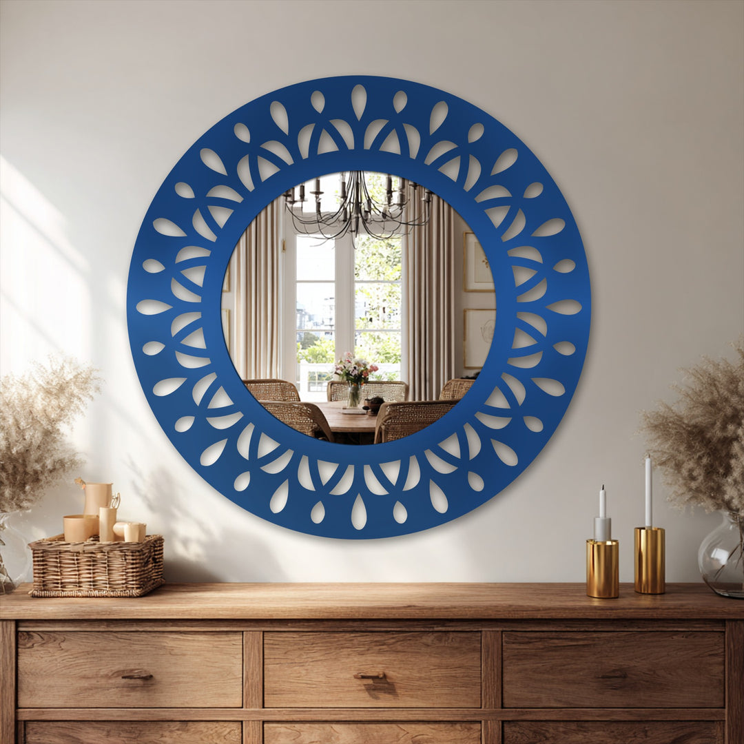 Intense color contrast highlights the striking blue of this leaf motif round modern mirror against the neutral-toned wall and wooden console table.