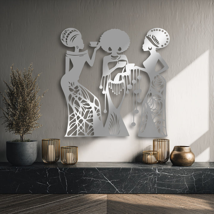 Negative space strikingly defines the intricate three-woman silhouette design of this unique metal wall art, contrasting with the textured wall.