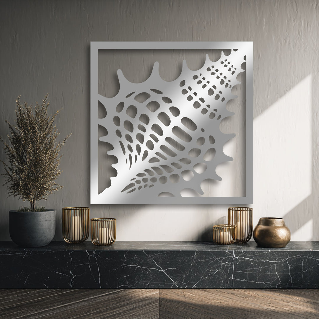 A warm color temperature from natural light illuminates the textured decorative metal art seashell frame above a dark marble shelf.