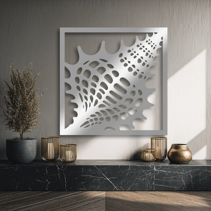 A warm color temperature from natural light illuminates the textured decorative metal art seashell frame above a dark marble shelf.